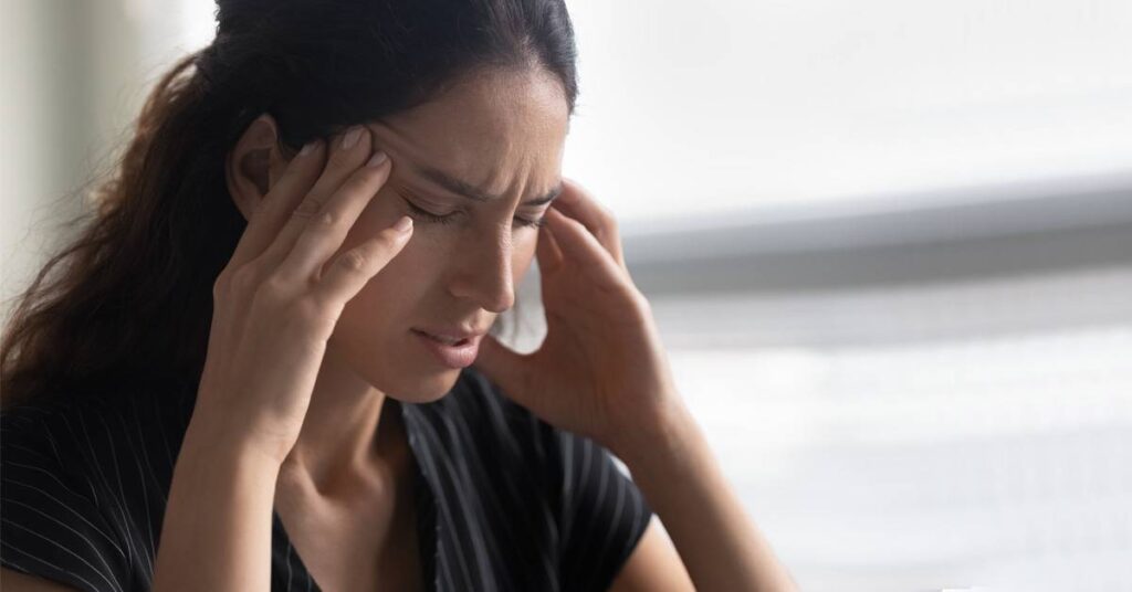 women rubbing head thinking about trauma and addiction treatment options