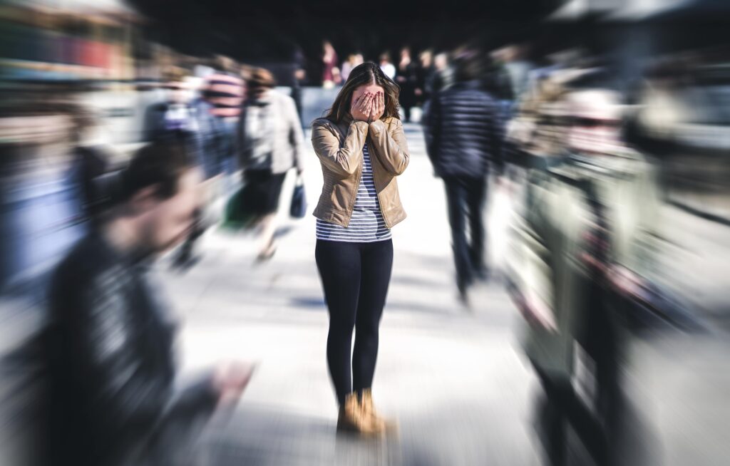 A woman in a crowded room having an anxiety attack.